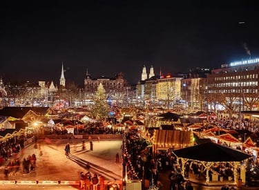 Night view of the Zurich Christmas market featuring an outdoor ice skating rink and festive stalls.