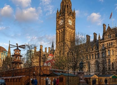 Manchester Town Hall and Christmas Market stalls featuring a large Santa and gothic clock tower.