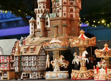 Handcrafted German Christmas market miniature castle, timber-frame houses, and rotating carousel figurines.
