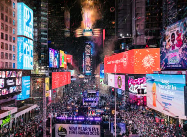 Crowds celebrate New Year's Eve in Times Square New York with confetti, fireworks, and bright digital billboards.