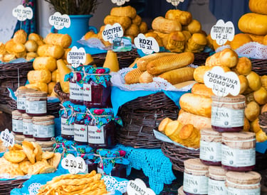 Display of traditional Polish Oscypek smoked sheep cheese and cranberry jam at a Zakopane market stall.