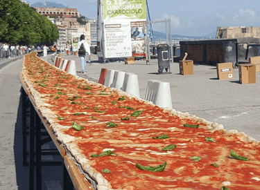 A record-breaking long pizza margherita on a table along the Lungomare Caracciolo in Naples, Italy.