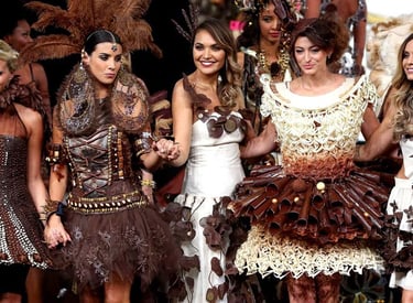 Models walking a runway in intricate chocolate dresses and edible fashion couture.