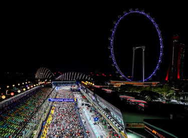 Night view of the Singapore Grand Prix F1 track with the illuminated Singapore Flyer Ferris wheel.