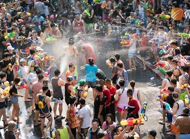 Crowds celebrate Songkran Festival in Thailand with a massive water gun fight on a busy street.
