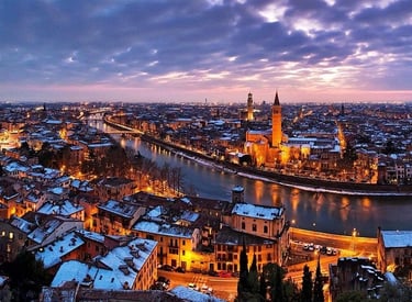 Aerial view of snow-covered Verona, Italy skyline and Adige River at twilight.