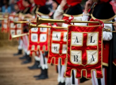 Medieval trumpet players in traditional costumes holding brass instruments with red and white heraldic banners.