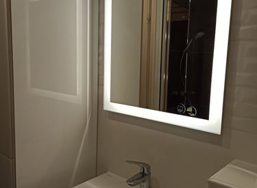 Salle de bain moderne avec miroir carré rétroéclairé LED au-dessus d'une vasque en céramique blanche
