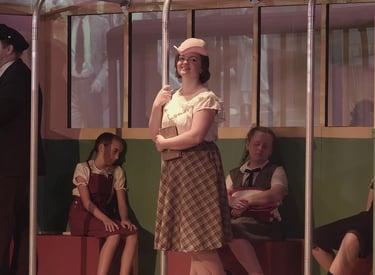 Character Young Catherine on a streetcar accompanied by younger siblings.