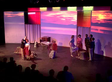 A group of young adults in a staged hiking scene. Vivid sunsets are on screens behind them.