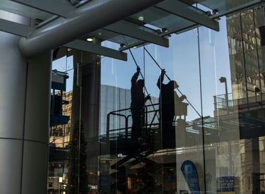 Ein Mann der ein großes Glasfenster sauber macht