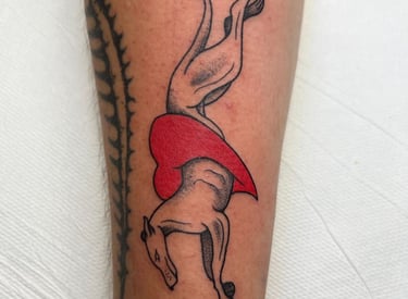 a tattoo of a dog jumping through a heart made at Inari Tattoo
