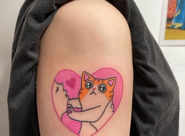 a cat with a heart shaped tattoo on the arm