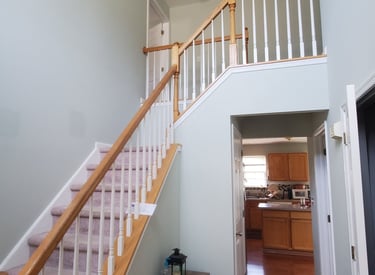 a painted foyer staircase way with a wooden stairs and wooden floor