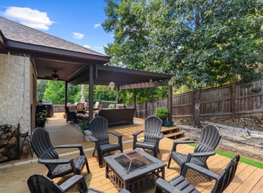 a patio with a fire pit and chairs