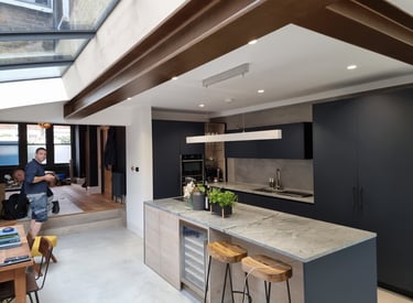 Interior kitchen painting project with navy cabinets and wood beams in Balham, by Pure Perfection