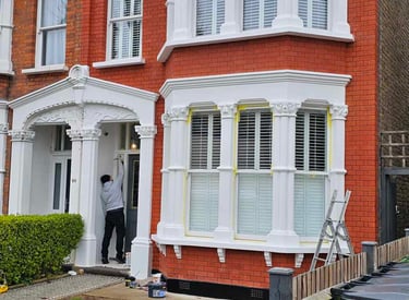 Exterior painting of red-brick house with white detailing in Balham, done by Pure Perfection