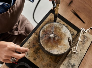 Joyero que utiliza un soplete de gas para soldar joyas artesanales