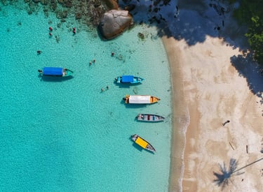 ein Strand mit Booten und Menschen auf und im Wasser