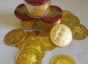 kopka zlatych minci na stole i v krabicke