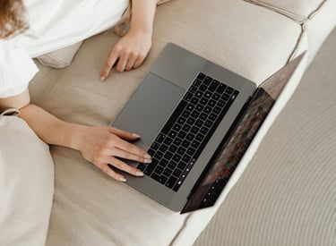a woman sitting on a couch with her laptop