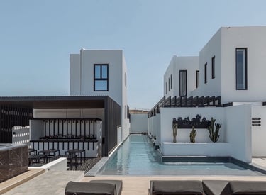 a pool with lounge chairs and a pool