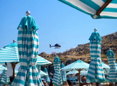 a helicopter flying over a beach with umbrellas