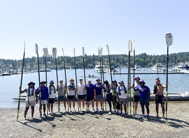Team standing together holding oars, ready to begin a rowing activity during a team-building retreat