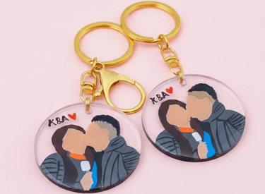 Llaveros de pareja personalizados en acrílico, con retratos sin rostro pintados a mano y herrajes dorados.