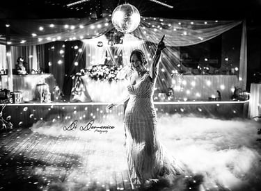 Mariée en robe sirène dentelle lors de l’ouverture de bal, fumées et boule à facettes N&B.