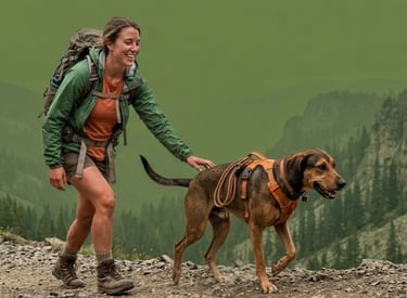 Mujer sonriente con mochila haciendo senderismo por un sendero de montaña con su perro