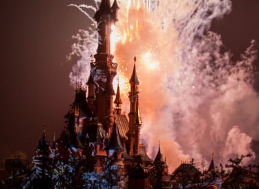 Espectáculo nocturno de fuegos artificiales iluminando el cielo sobre el Castillo de Disney