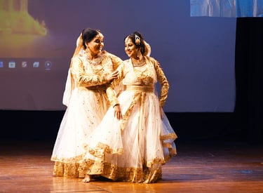 Mrs. Chaitali Biswas gracefully performing a kathak dance in traditional attire on stage.