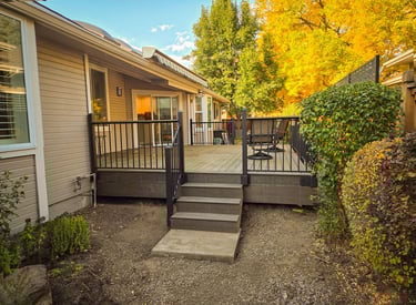 Completed backyard deck with stairs and black metal railing system