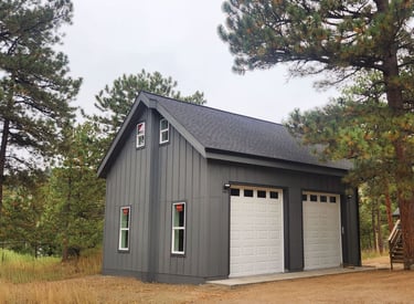 Side profile of a custom mountain garage with dark vertical siding.
