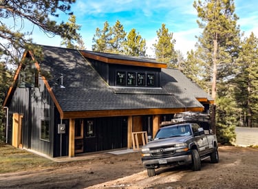 Modern detached garage with dark siding and wood trim built by Elk Valley Contractors in Evergreen, Colorado.