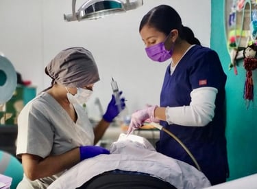 Dos dentistas con herramientas de limpieza dental atendiendo a un paciente