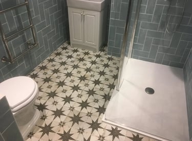 Bathroom renovation with patterned floor tiles and walk-in shower in Brighton property.