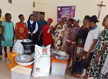Community Outreach workshop attendees gather around donated food supplies and household goods.