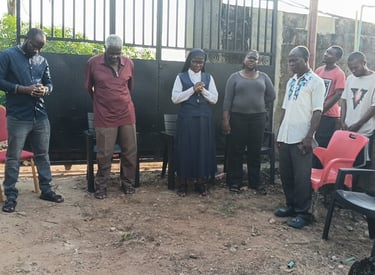 A group of people and a Catholic nun standing outdoors for a community prayer gathering.