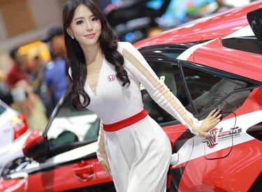 a woman in a white dress standing next to a red car
