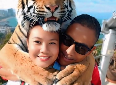 Mark Adam Cottonham and his wife hugging a tiger in Thailand