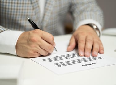 a man in a suit and tie is writing a letter to someone