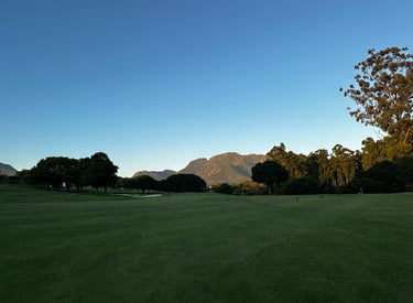 a golf course with a view of the mountains