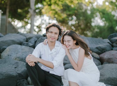 Intimate couple sitting on rocks during sunset session at Novotel Tanjung Benoa Bali.