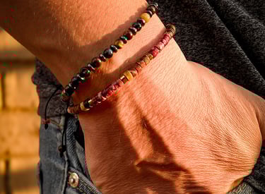 mano con pulseras de piedras en la bolsa de jeans