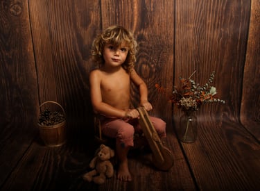 photo d'un petit garçon sur un vieux vélo en bois sur un fond bois 