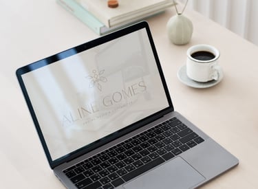Uma tela de laptop exibindo uma wallpaper com a logo criada. Uma xícara de café está na mesa ao lado