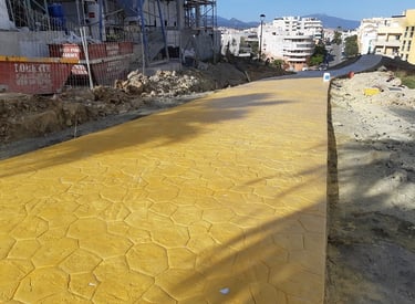 Camino de hormigón impreso en color albero con diseño hexagonal, ideal para zonas urbanas y paisajísticas.