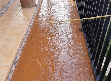 Renovación de suelo de hormigón con acabado en resina de color tostado en un patio .